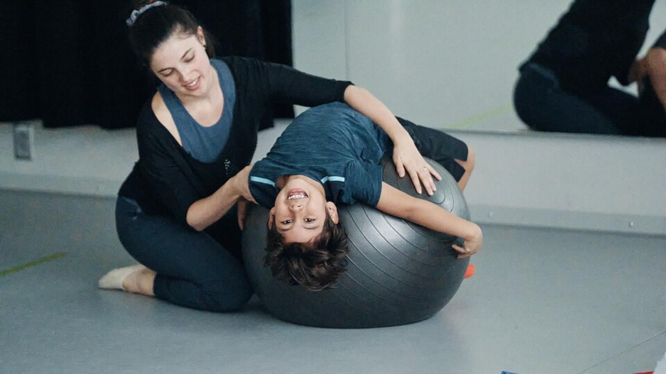 Il fait un exercice avec un gros ballon.                   