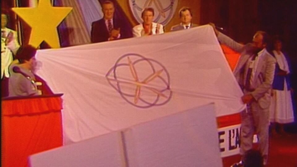 Un drapeau est étendu et tenu par deux personnes.