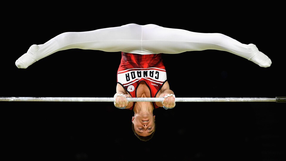 René Cournoyer en action à la barre horizontale aux Jeux du Commonwealth