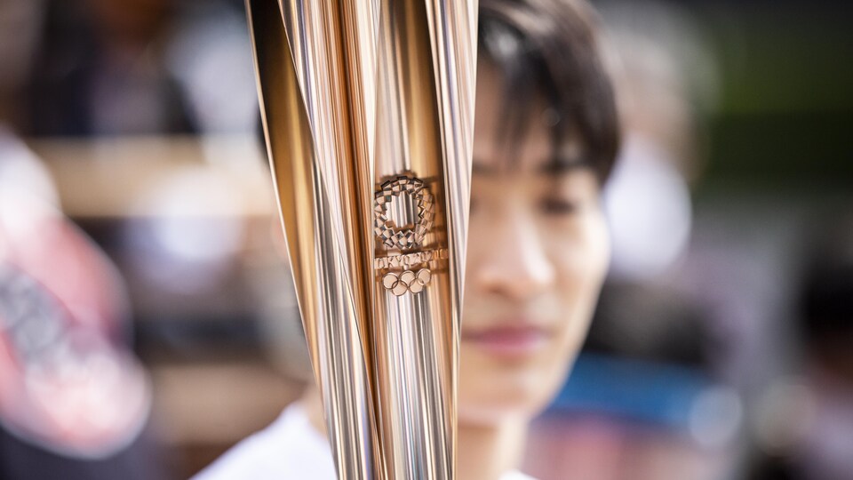 Le flambeau olympique porté par un coureur.