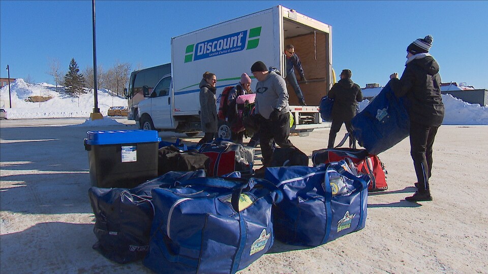 Des sacs de sport devant un camion