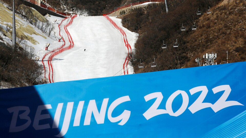 L'inscription Beijing 2022 sur un panneau géant devant une piste de ski enneigée.