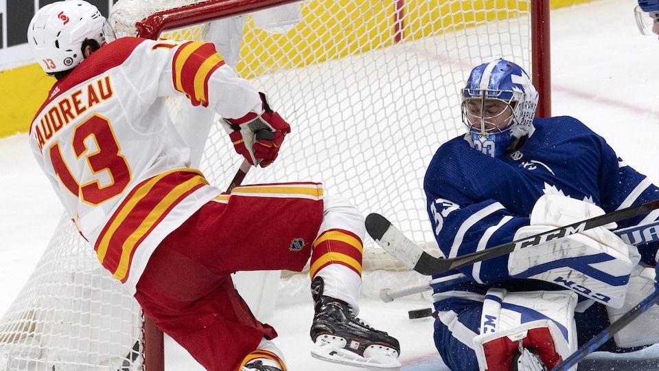 L'attaquant des Flames fait un vol plané alors qu'il voit la rondelle glisser dans le filet des Maple Leafs, derrière le gardien, impuissant.