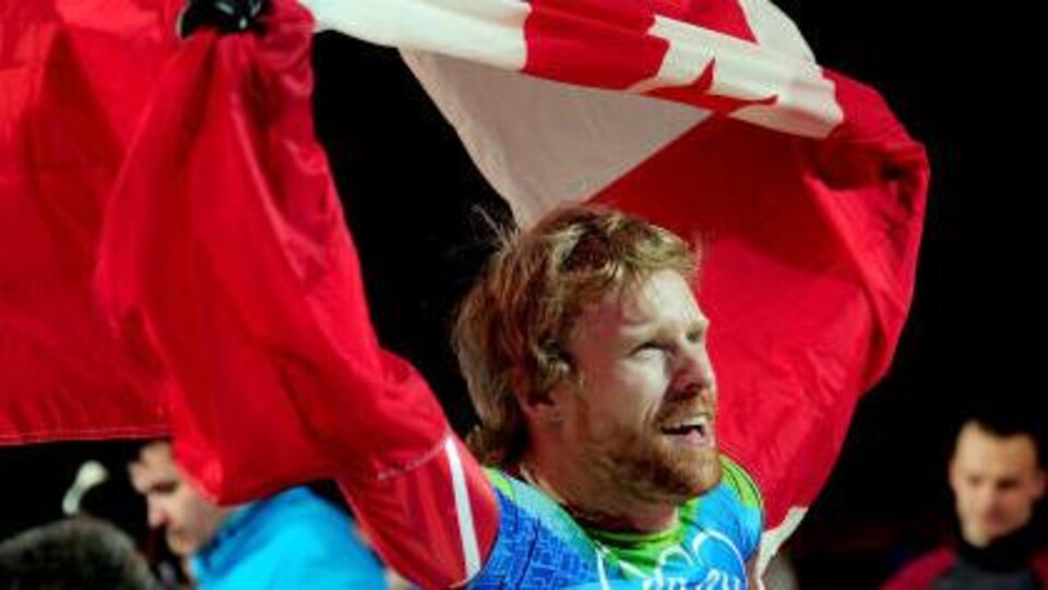 Il porte le drapeau canadien à bout de bras.