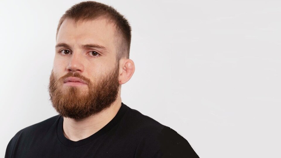 Jordan Steen, vêtu d'un t-shirt noir, regarde la caméra.