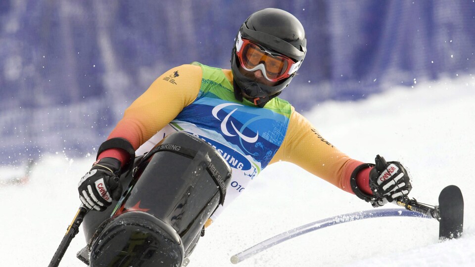 Un skieurs en position assise dans un virage
