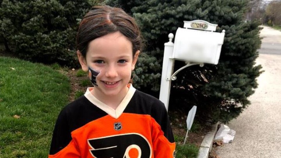 Elle pose devant chez elle avec un chandail des Flyers de Philadelphie.