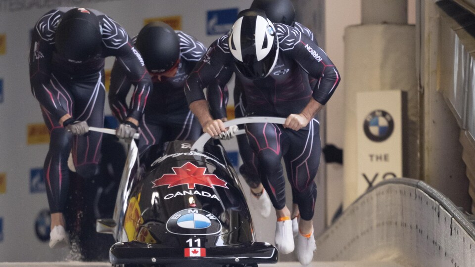 Il pousse leur bobsleigh.