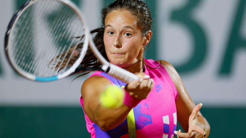 The close-up player returns the ball using the forehand. 