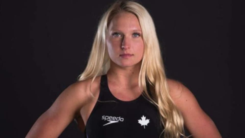 Kate Sanderson en maillot fait face à l'appareil photo les mains sur les hanches.