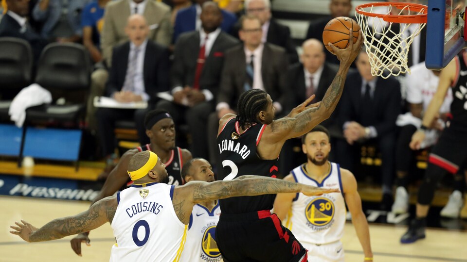Surveillé par DeMarcus Cousins, Kawhi Leonard réussit un panier contre les Warriors.