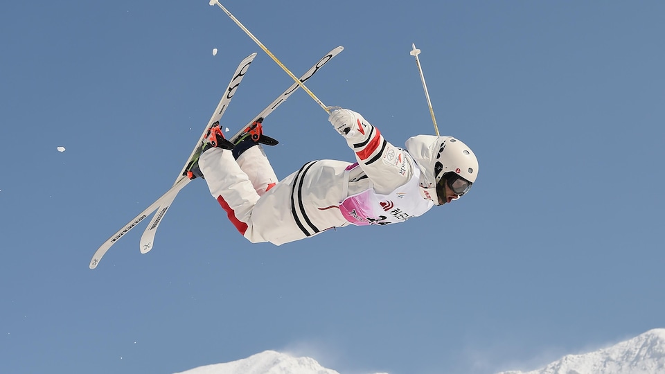 Un skieur exécute un saut vers l'avant.