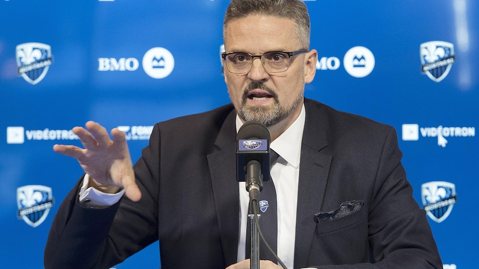 Il fait un geste de la main droite en conférence de presse.