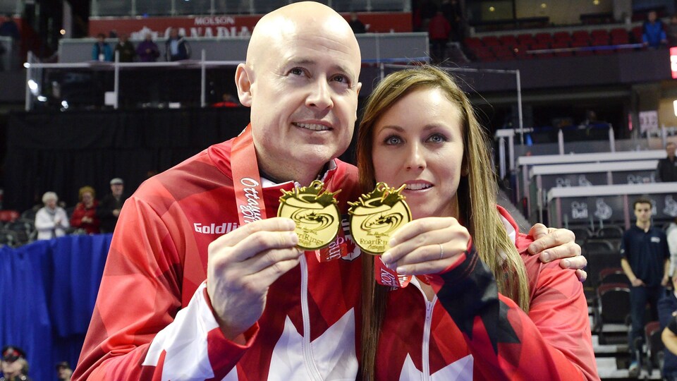 Les athlètes de curling Kevin Koe et Rachel Homan tenant leurs médailles d'or lors des Jeux olympiques de 2018.