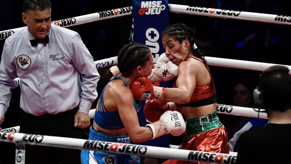 Deux boxeuses s'échangent des coups dans un ring.