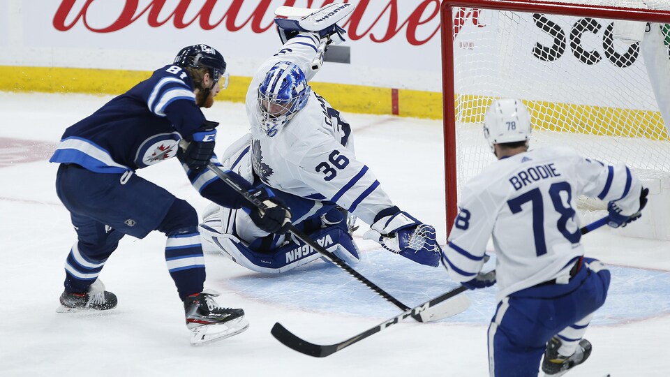 L'attaquant des Jets tire du revers dans le filet des Leafs, alors que leur gardien Jack Campbell plonge pour essayer d'arrêter la rondelle.