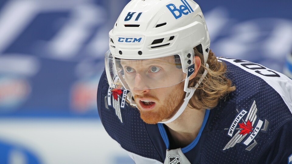 Close-up of a helmeted player with his mouth open while playing.