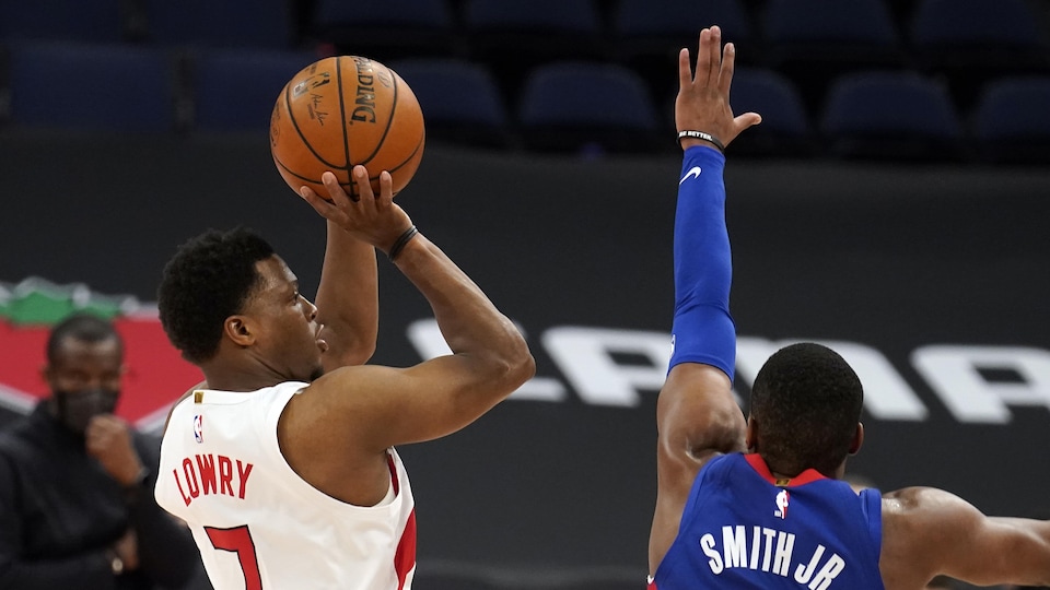 Le numéro 7 des Raptors s'apprête à tirer, tandis qu'un adversaire plonge pour le bloquer.