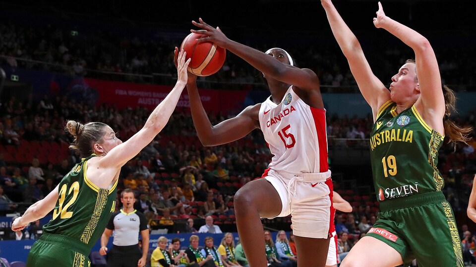 La basketteuse canadienne Laeticia Amihere tente une percée, le ballon dans ses mains, entre deux rivales australiennes.