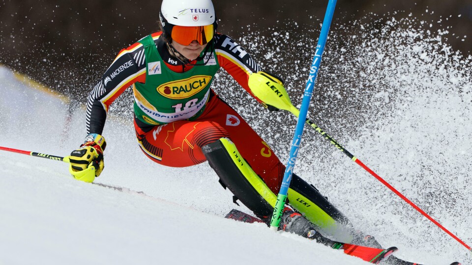 Une skieuse en plein effort passe une porte dans un slalom de Coupe du monde.