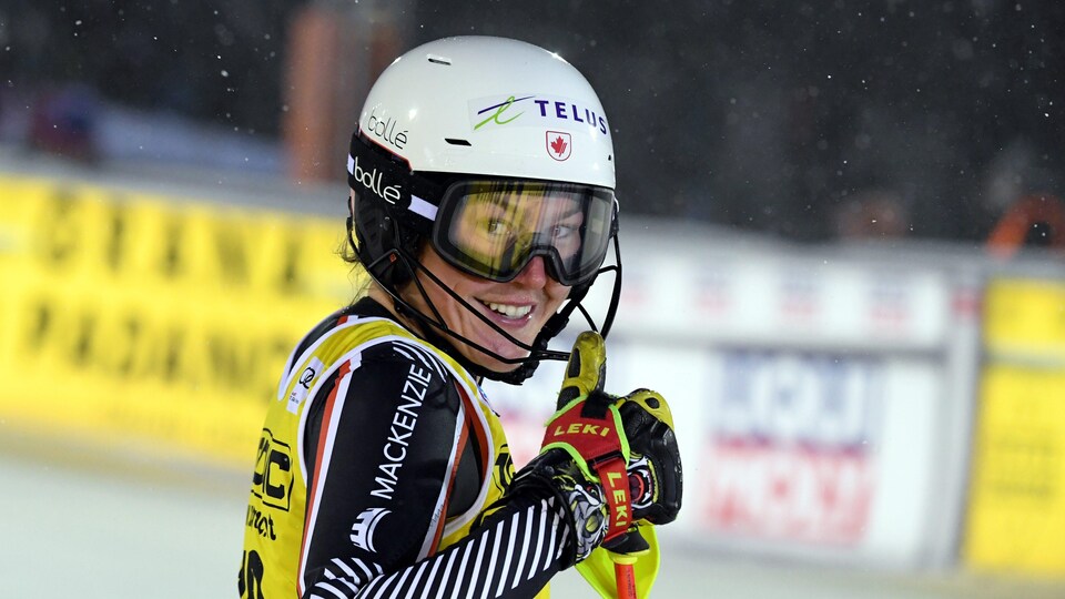 La skieuse lève le pouce pour la caméra après une bonne descente.