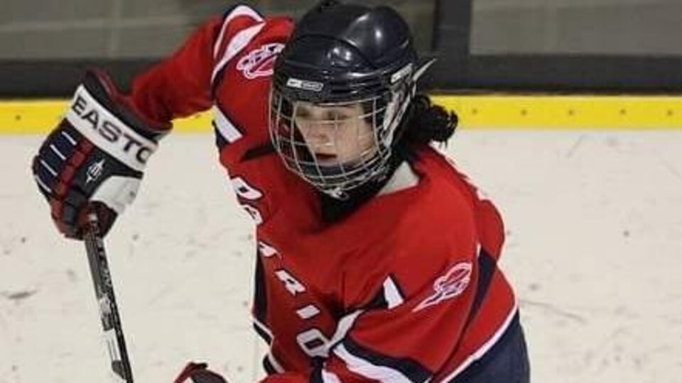 Une joueuse de hockey patine avec la rondelle.