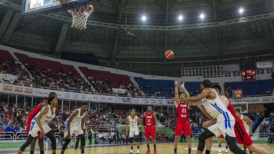 Des joueurs sont sur un terrain de basketball.