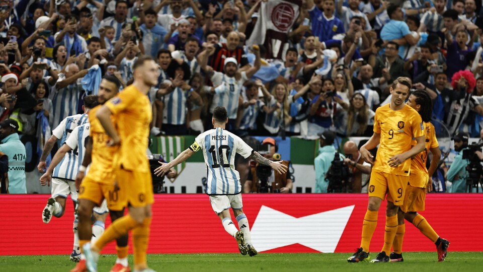 Devant une foule en délire, Messi prend son élan entre des joueurs adverses pour célébrer sa réussite.