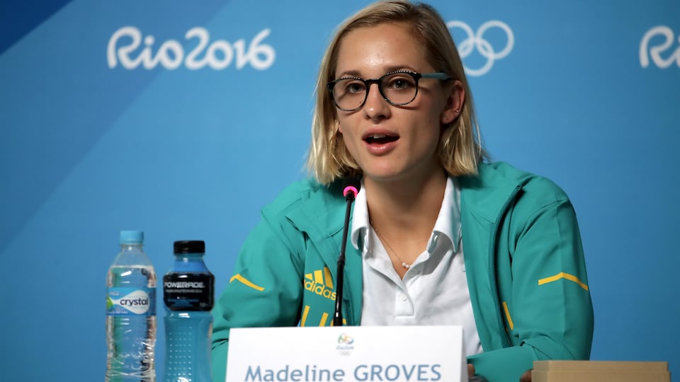 La nageuse, vêtue d'un survêtement d'entraînement, est assise derrière un micro pour répondre à des questions aux Jeux de Rio.