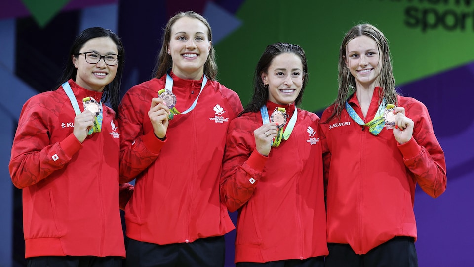 Quatre femmes présentent leur médaille.
