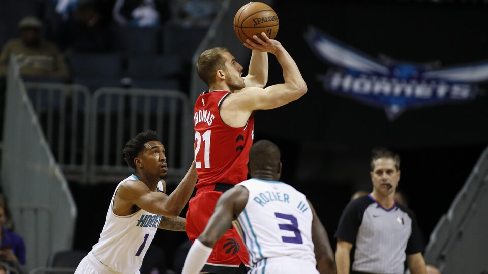 Thomas tente un tir entre les deux joueurs des Hornets.