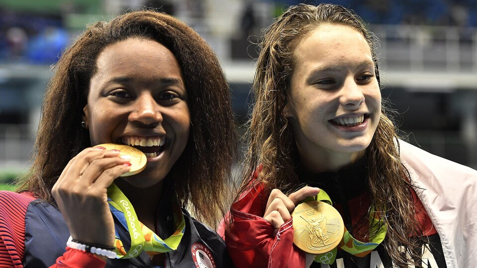 L'Américaine Simone Manuel et la Canadienne Penny Oleksiak posent pour les photographes après avoir reçu leur médaille d'or.