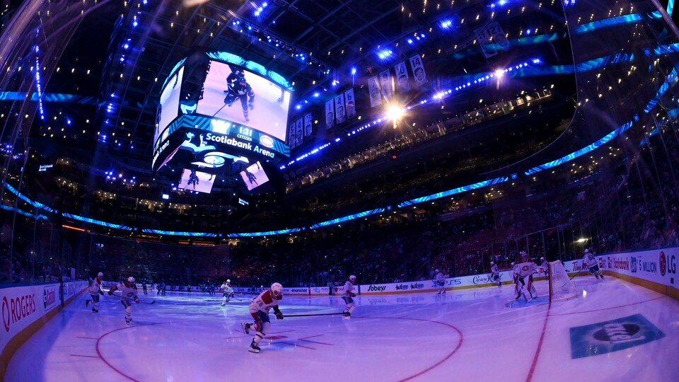 Les joueurs des Canadiens et des Maple Leafs sautent sur la patinoire en prévision du match d'ouverture de la saison 2021-2022.