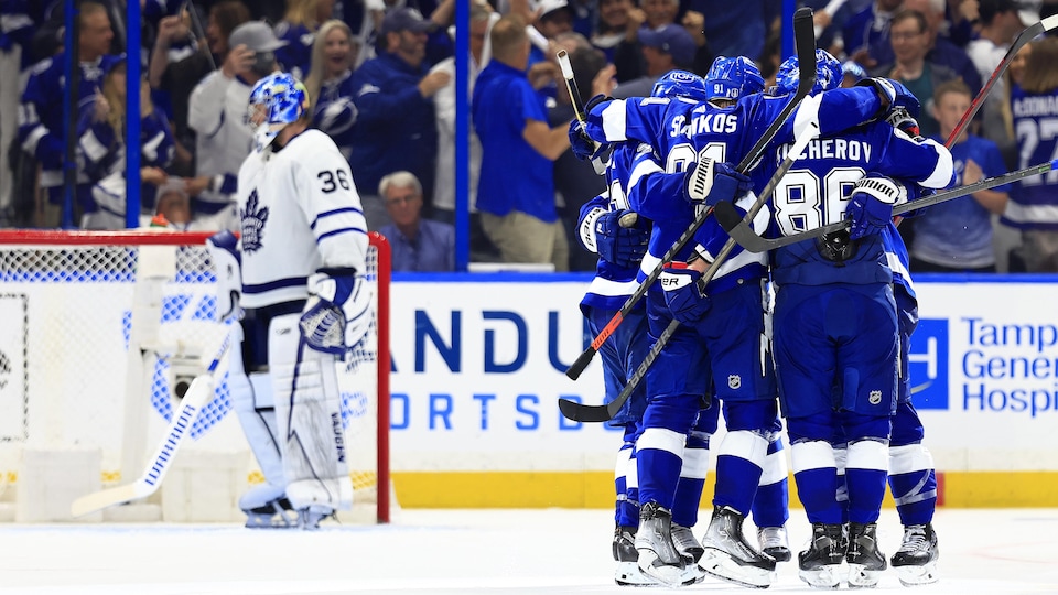 Cinq joueurs de hockey s'enlacent après un but de Nikita Kucherov.