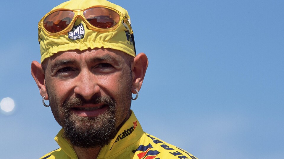 Close-up of a cyclist with a yellow headband and jersey