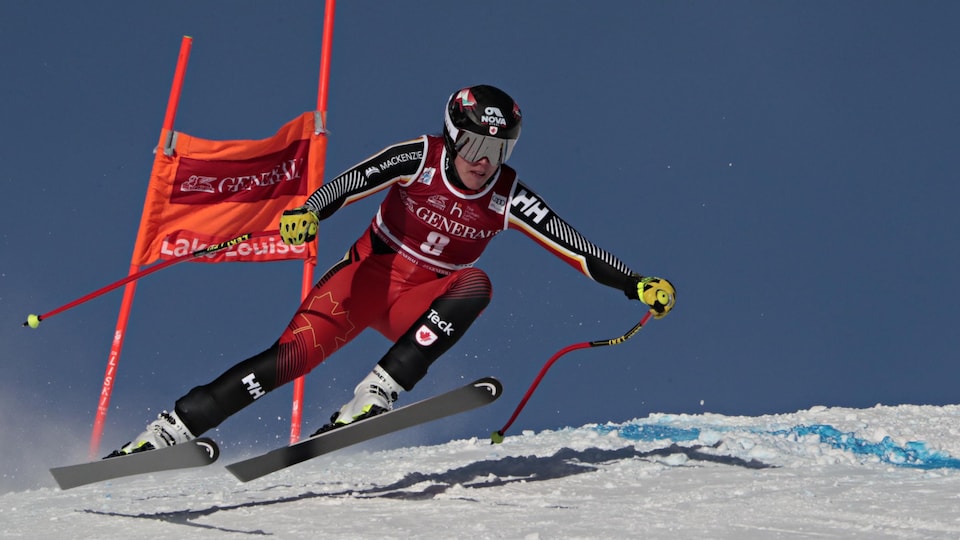 Une skieuse tente de garder son équilibre en dévalant une pente.