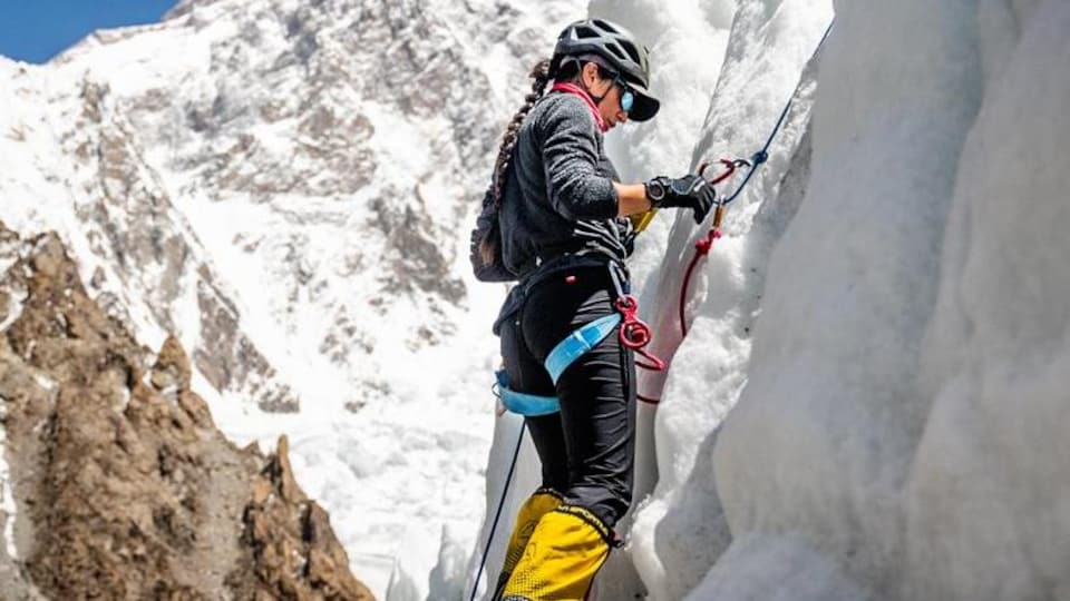 Une alpiniste grimpe une paroi de glace
