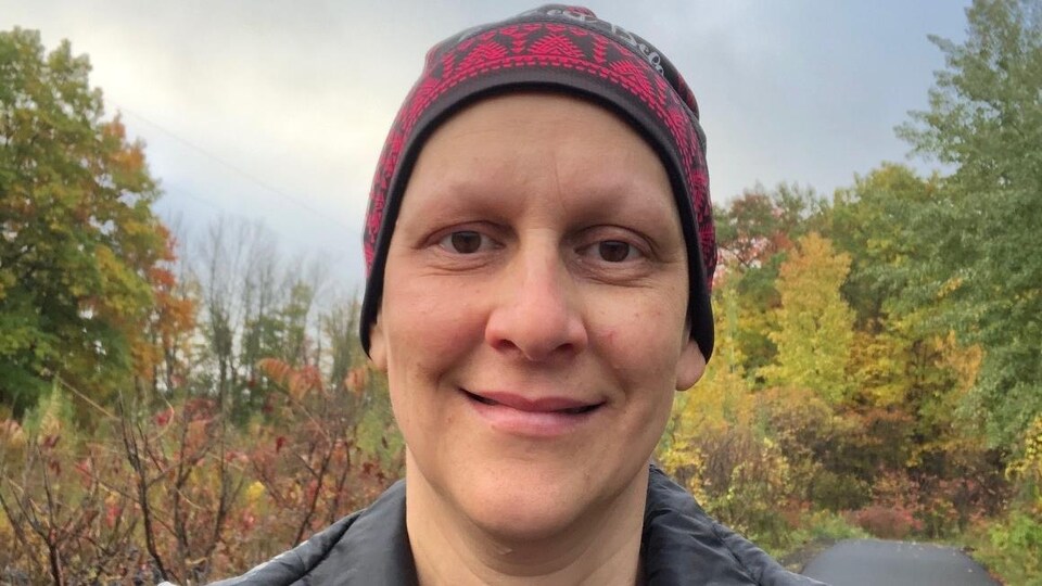 Gros plan d'une femme avec une tuque qui se promène en forêt