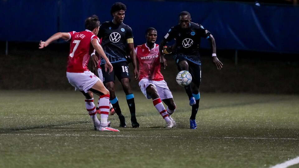 Des joueurs se battent pour le ballon.
