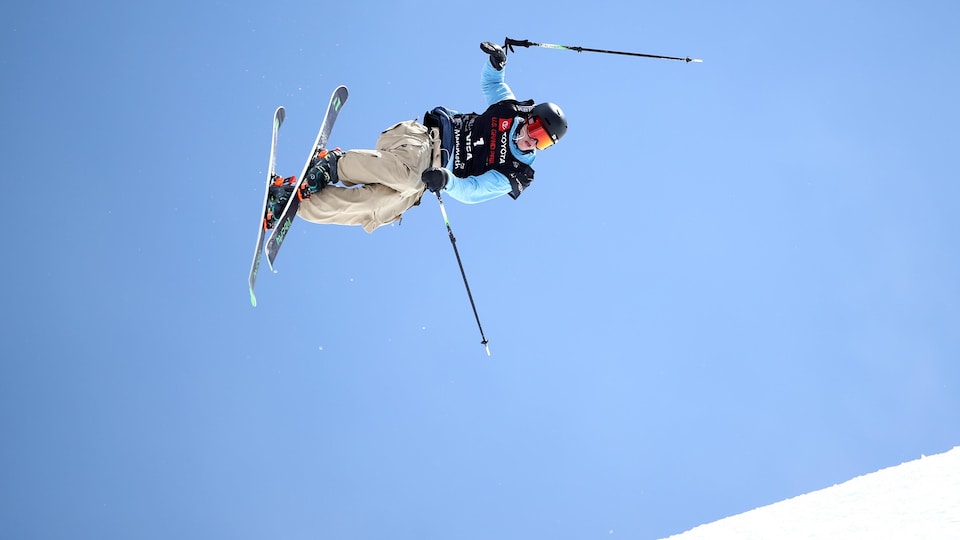 Un skieur fait une manœuvre dans les airs.