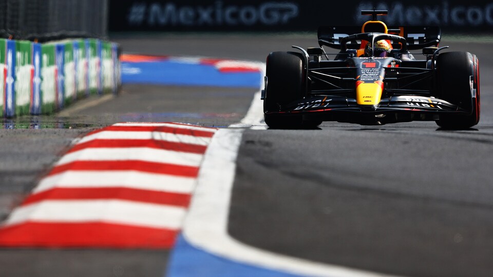 Max Verstappen, dans sa Red Bull, s'apprête à attaquer un virage, les vibreurs à la droite de sa voiture. 