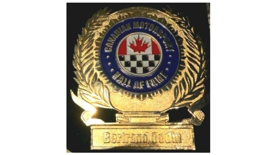 Close-up of a gold medal with the Canadian flag in the center and a checkered flag