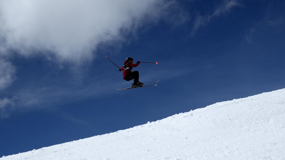Une skieuse réalise un saut.