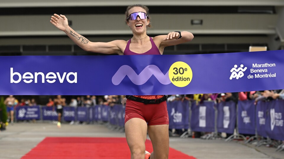 La marathonienne Mélanie Desautels traverse le fil d'arrivée.

