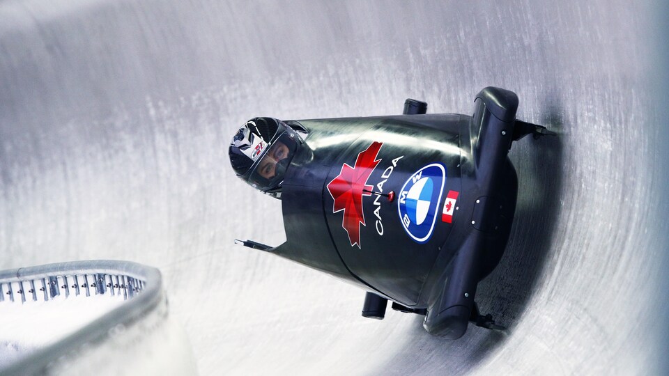 Installée seule dans son bobsleigh, elle effectue une descente.
