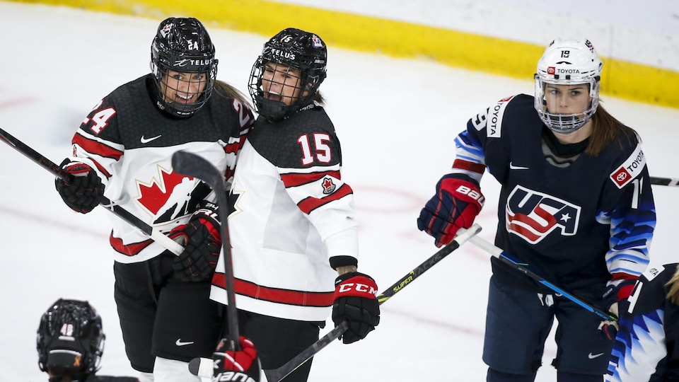 Deux joueuses de hockey célèbrent un but.