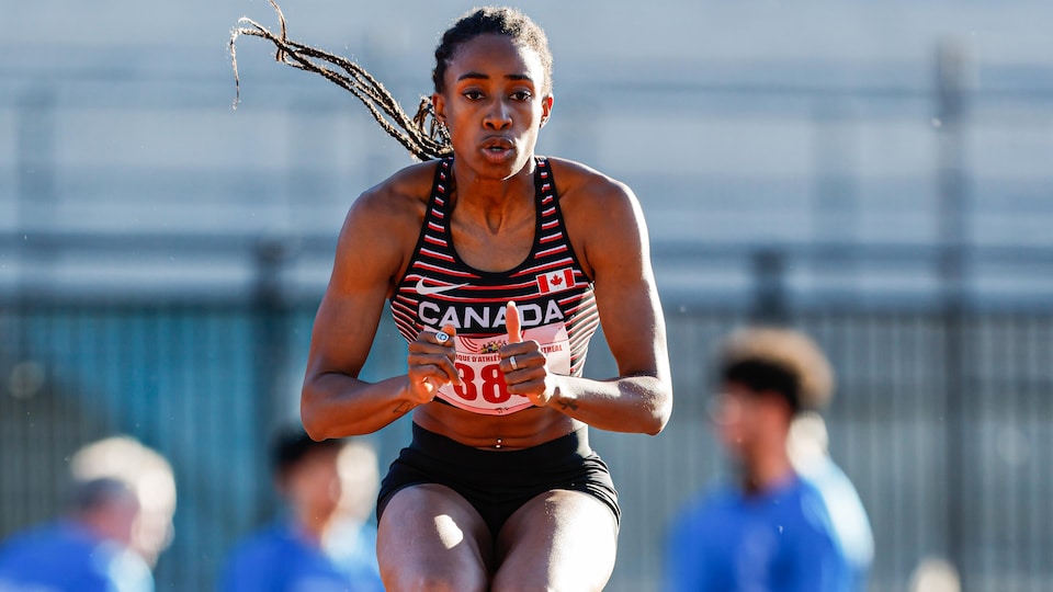 An athlete performs a jump on an athletics track.