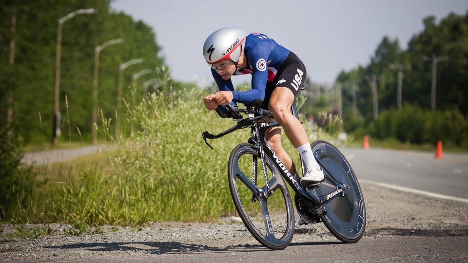 Il est en position aérodynamique sur son vélo.