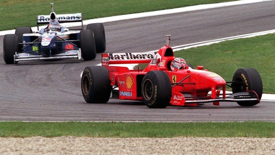 Deux voitures F1 se suivent de près sur une piste de course.