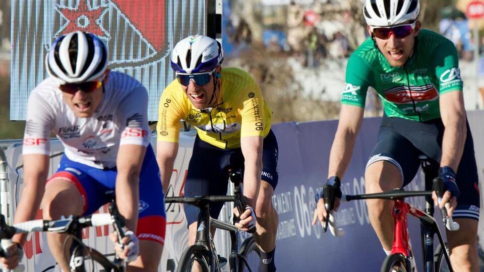 Trois cyclistes pédalent.